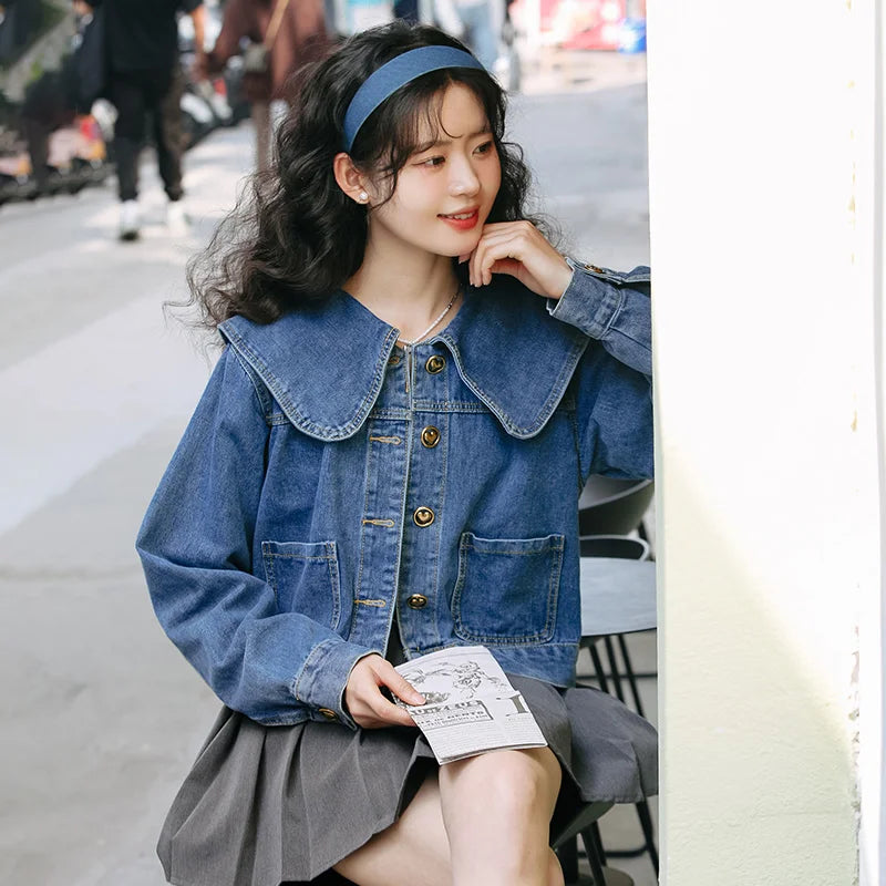 A fashionable women's denim jacket with a Peter Pan collar and button-up design, featuring practical pockets for a stylish and versatile look.