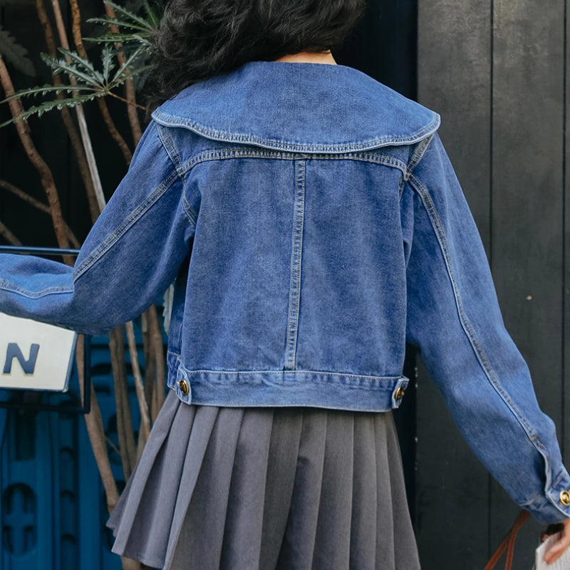 A fashionable women's denim jacket with a Peter Pan collar and button-up design, featuring practical pockets for a stylish and versatile look.