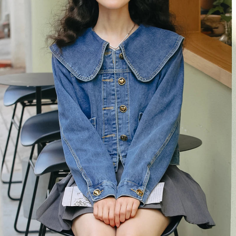 A fashionable women's denim jacket with a Peter Pan collar and button-up design, featuring practical pockets for a stylish and versatile look.